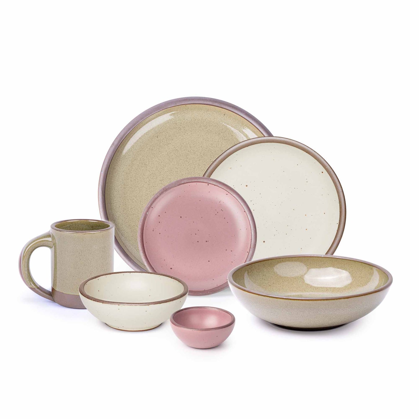 The side plate and breakfast bowl in warm off-white, the bitty bowl and cake plate in dusty mauve pink, the mug, the everyday bowl and dinner plate in a reflective dappled grey-green color.