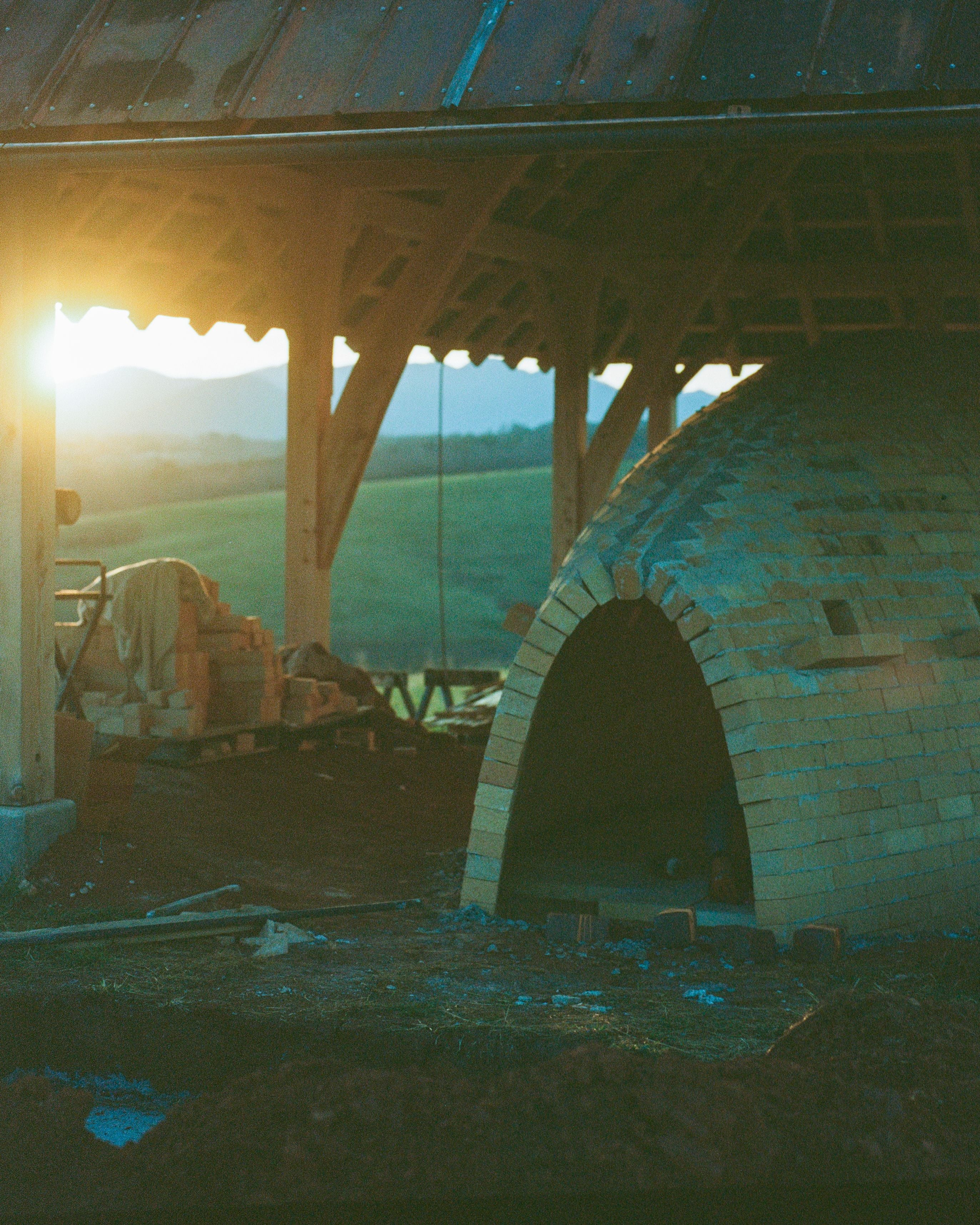 A brick kiln outside with a sunset in the background
