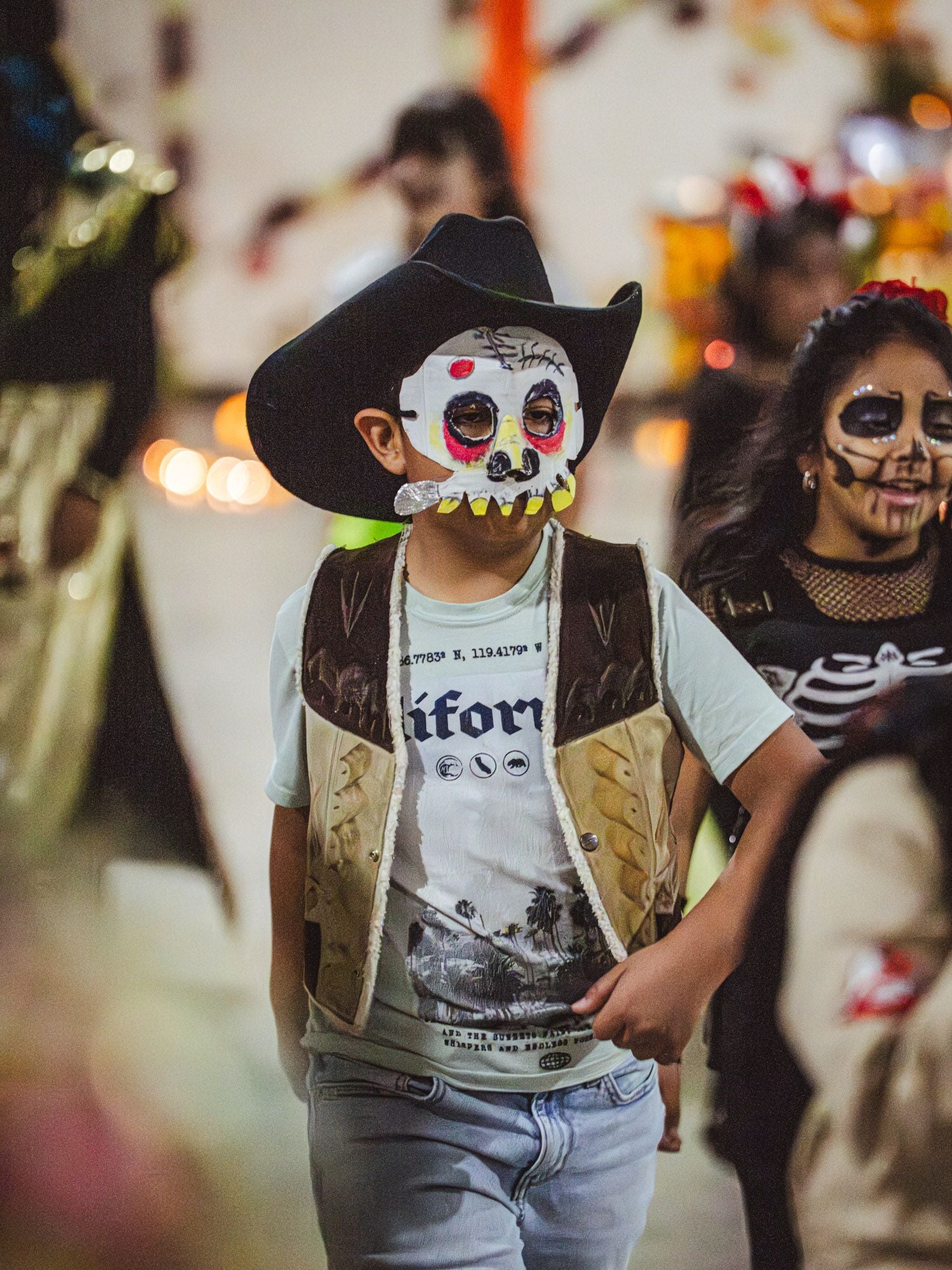 Two children dancing in face paint and face masks at a festival
